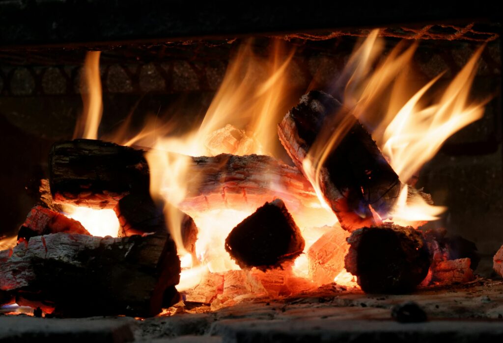 Close-up view of vivid flames and burning firewood in a cozy indoor fireplace.