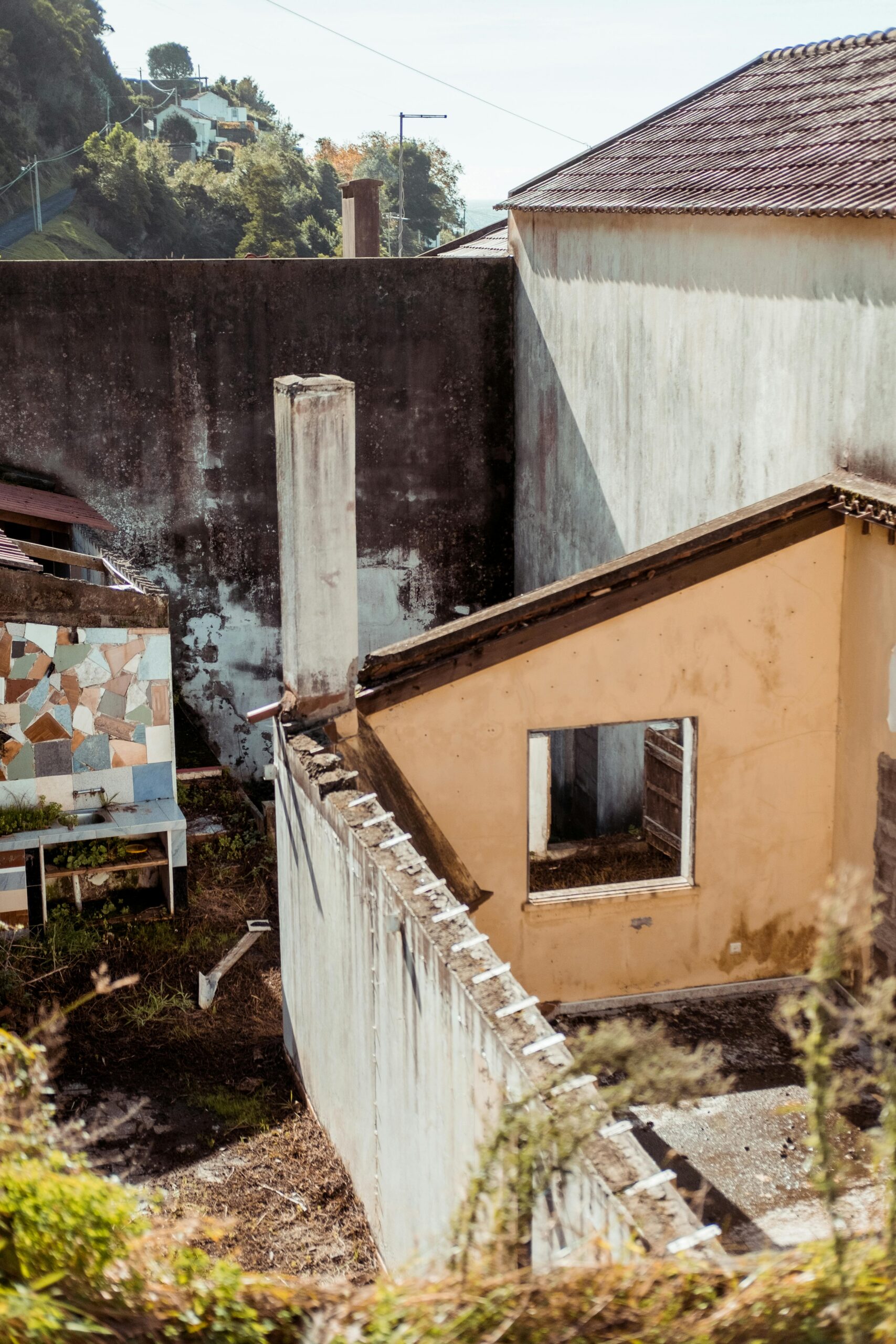 Charming rustic building exterior with mosaic wall, showcasing urban decay in daylight.