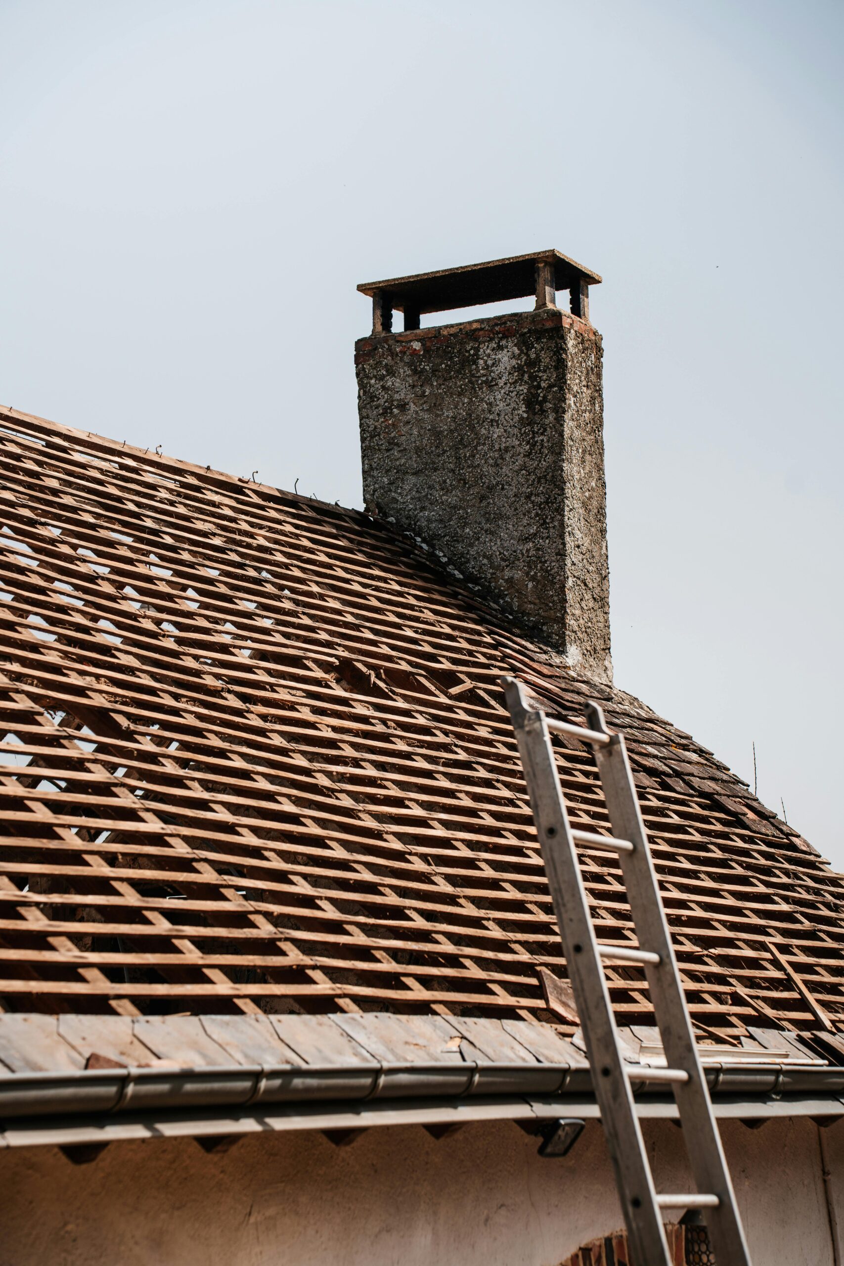A traditional rooftop under renovation with visible chimney and ladder.
