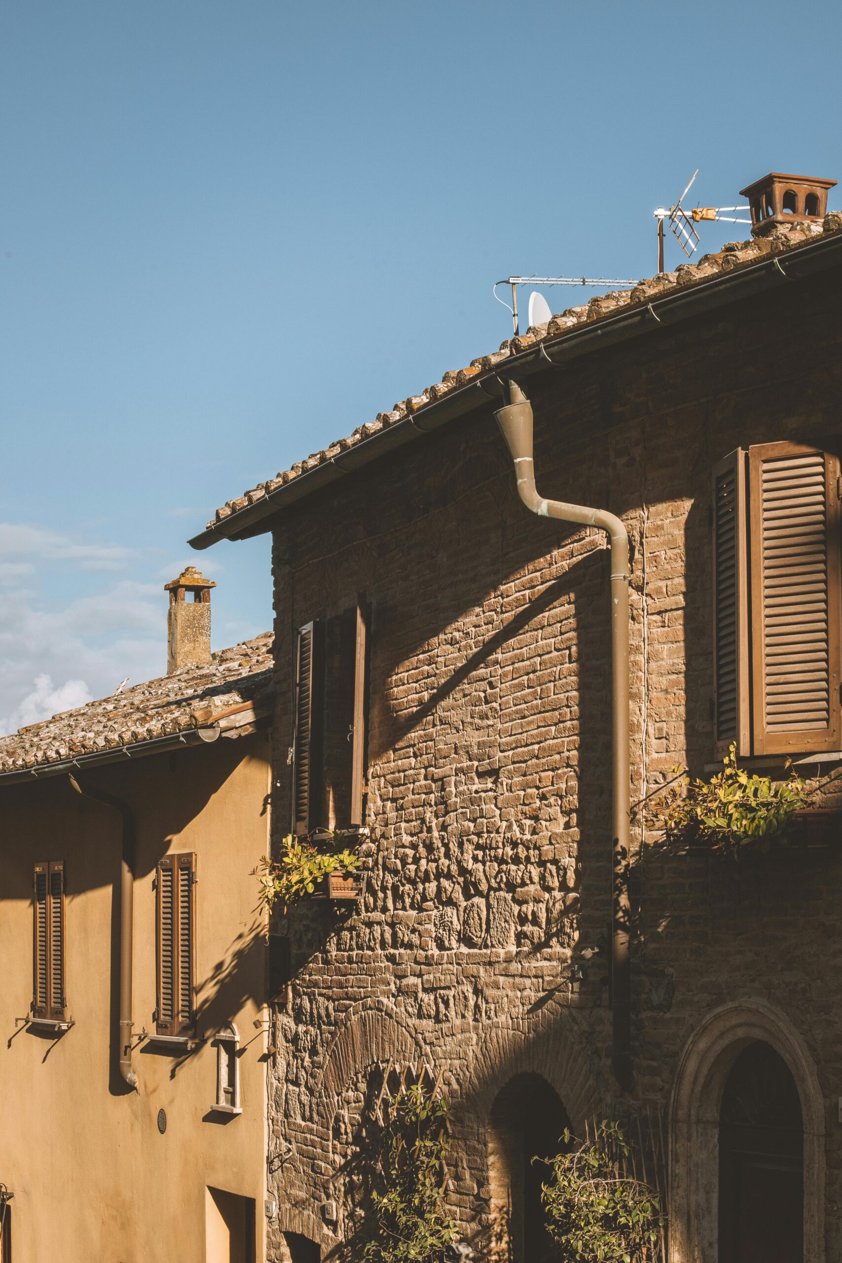 Charming rustic Italian architecture with brickwork under a clear blue sky, capturing serene beauty.